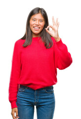 Poster - Young asian woman wearing winter sweater over isolated background smiling positive doing ok sign with hand and fingers. Successful expression.