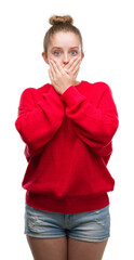 Sticker - Young blonde woman wearing bun and red sweater shocked covering mouth with hands for mistake. Secret concept.