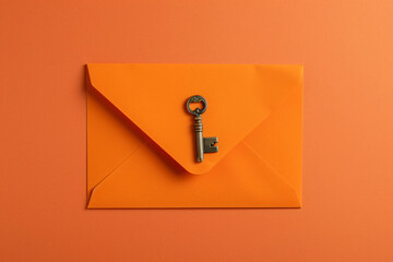 Poster - orange envelope with key on orange background flat lay top view


