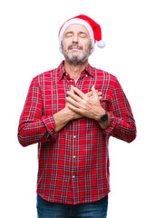 Canvas Print - Middle age hoary senior man wearing christmas hat over isolated background smiling with hands on chest with closed eyes and grateful gesture on face. Health concept.