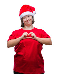 Wall Mural - Young adult woman with down syndrome wearing christmas hat over isolated background smiling in love showing heart symbol and shape with hands. Romantic concept.