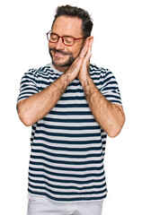 Poster - Middle age man wearing casual clothes and glasses sleeping tired dreaming and posing with hands together while smiling with closed eyes.