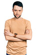 © Krakenimages.com - Hispanic man with beard wearing casual t shirt skeptic and nervous, disapproving expression on face with crossed arms. negative person.