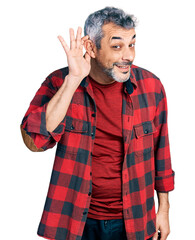 Canvas Print - Middle age hispanic with grey hair wearing casual shirt smiling with hand over ear listening and hearing to rumor or gossip. deafness concept.