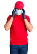 © Krakenimages.com - Young hispanic man wearing covid-19 safety mask suffering from headache desperate and stressed because pain and migraine. hands on head.