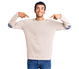 Wall Mural - Young african amercian man wearing casual clothes looking confident with smile on face, pointing oneself with fingers proud and happy.