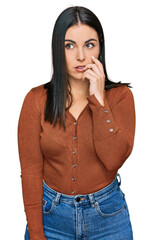 Wall Mural - Young hispanic woman wearing casual clothes looking stressed and nervous with hands on mouth biting nails. anxiety problem.