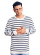 © Krakenimages.com - Hispanic handsome young man wearing casual clothes and glasses with hand on stomach because indigestion, painful illness feeling unwell. ache concept.