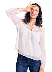 Poster - Young beautiful hispanic woman wearing casual clothes smiling happy doing ok sign with hand on eye looking through fingers