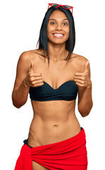 Wall Mural - Young african american woman wearing bikini success sign doing positive gesture with hand, thumbs up smiling and happy. cheerful expression and winner gesture.