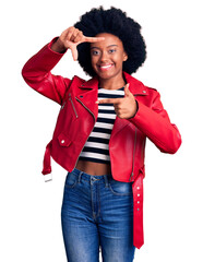 Canvas Print - Young african american woman wearing red leather jacket smiling making frame with hands and fingers with happy face. creativity and photography concept.