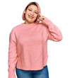 © Krakenimages.com - Hispanic woman with pink hair wearing casual winter sweater smiling pointing to head with one finger, great idea or thought, good memory
