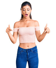 Wall Mural - Young beautiful woman wearing casual clothes pointing down with fingers showing advertisement, surprised face and open mouth