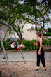 © Иванна Емельянова - A mother pushing her son on a swing at the playground, both smiling and enjoying a joyful moment of play and bonding outdoors.