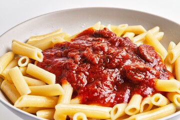 Wall Mural - A close-up view of a plate of pasta with tomato sauce, invoking the essence of italian cuisine.