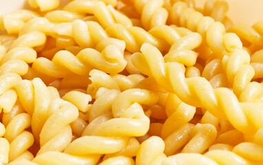 Wall Mural - Close-up of cooked fusilli pasta with a glossy surface, ideal for culinary themes and recipe visuals.