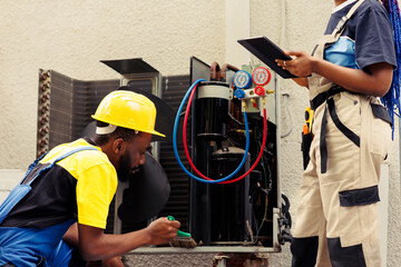 Wall Mural - Diverse team of engineers contracted to fix broken air conditioner. Coworkers investigating malfunctioning blower fan causing frozen evaporator coil, resulting in poor airflow