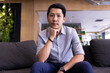 © Wavebreak Media - Sitting on couch, man in casual attire looking at camera in modern office