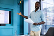 © Wavebreak Media - Presenting data, man holding papers and pointing at screen in modern office