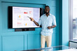 © Wavebreak Media - Presenting annual report, man pointing at screen with graphs in modern office