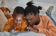 © peopleimages.com - Relax, tablet and black children on bed for education, learning or skill development in bedroom. Online, night and kids with ebook subscription for information, literacy or knowledge in home