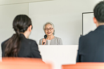 Canvas Print - 講演会・セミナー・講習会で講演・演説をする女性ビジネスウーマン（講師・先生・社長・代表）
