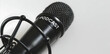 © sornram - Close-up of a black microphone labeled 'Podcast' symbolizing modern audio broadcasting and recording technology on white background.