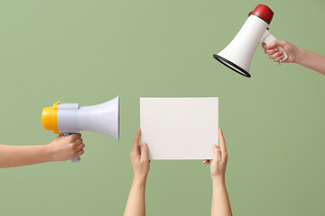 Wall Mural - Female hands with megaphones and blank poster on green background