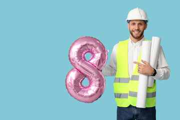 Canvas Print - Young male architect with balloon in shape of figure 8 on blue background. International Women's Day