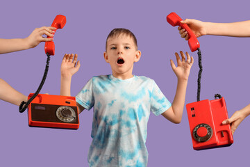 Wall Mural - Shocked little boy and hands with retro phones on purple background