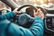 © ttonaorh - Close up of male hands on steering wheel of a car driving on the road