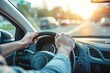 © ttonaorh - Close up of male hands on steering wheel of a car driving on the road