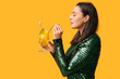© Pixel-Shot - Beautiful young woman with glass of tasty cocktail on yellow background