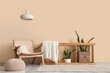 © Pixel-Shot - Interior of stylish living room with armchair and houseplants near beige wall
