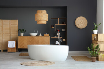 Poster - Interior of modern bathroom with bathtub, wooden furniture and houseplants