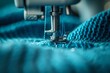 © anatolir - Macro shot highlighting the precision of a sewing machine needle on textured blue fabric