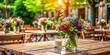 © Sujid - Flowers arranged beautifully on a rustic wooden table at an outdoor restaurant, floral, centerpiece, decor, garden, dining