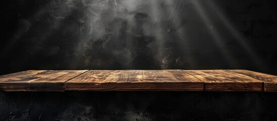 Wall Mural - A wooden table with a black background and a light shining on it