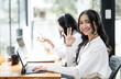 © NAMPIX - Portrait of cheerful business woman with headset showing OK sing at call center office