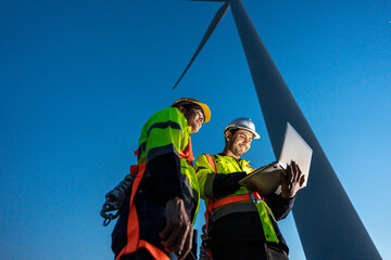 Diverse ethnicity male technicians working in the wind turbines field.