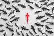 © Ben Kuang - Red fish swimming against black school on white background, symbolizing individuality.