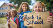 © Kien - A group of children holding signs with the words 'Back to School' written on them, smiling and looking at camera in front view