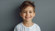 © Bambalino Studio - A young boy with a white shirt and brown hair is smiling. He is looking at the camera and he is happy