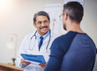 © peopleimages.com - Clipboard, healthcare or results with doctor and patient in hospital for appointment, assessment or checkup. Diagnosis, explain and medical with medicine professional talking to man in clinic