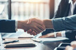 © CozyDigital - Business handshake. Successful conclusion of deal. Lots of documents on the table