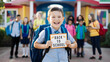© Deedyy - Cheerful boy holding blackboard with back to school sign. Boy with backpack holding in his hand chalk board with inscription Back to school. Cute smiling schoolboy in uniform standing with blackboard.
