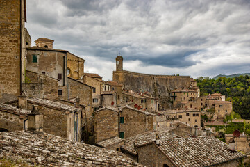 Wall Mural - A glimpse of the ancient medieval village of Sorano, on a melancholy and rainy spring day. In the province of Grosseto, Tuscany, Italy. The old houses built in stone and tuff bricks.