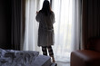 © nuclear_lily - Woman in Robe Opening Curtains to Morning Light