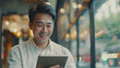 © Mahemud - Isolated studio background featuring an Asian man using a digital tablet, possibly searching for finance apps, fintech investments, or insurance budgeting.