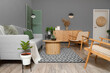 © Pixel-Shot - Interior of modern living room with grey sofa, armchairs and coffee table